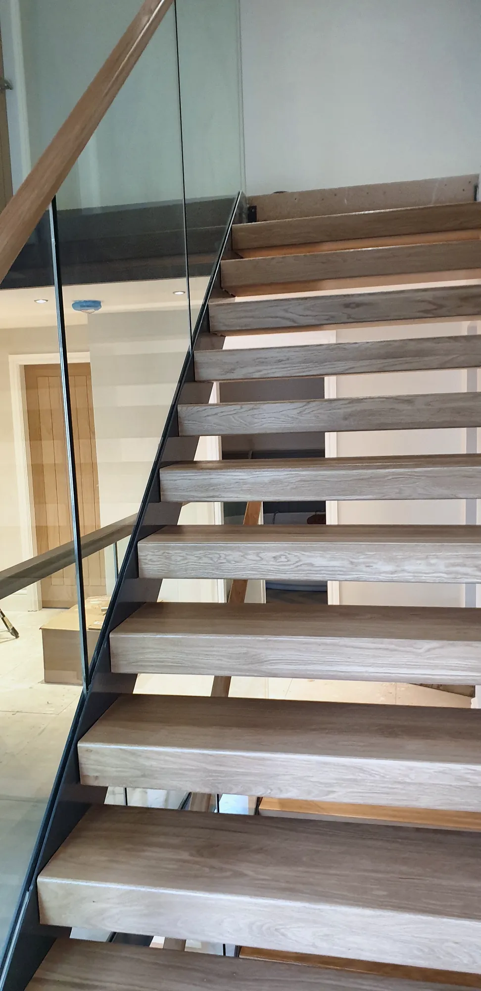 Floating oak staircase with a frameless glass balustrade