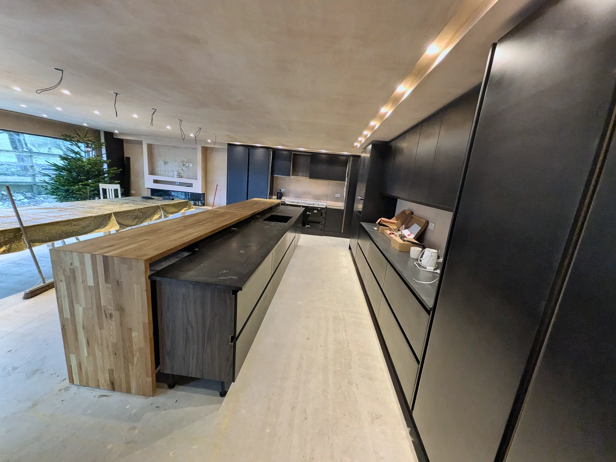 Handleless black kitchen with a solid oak island end
